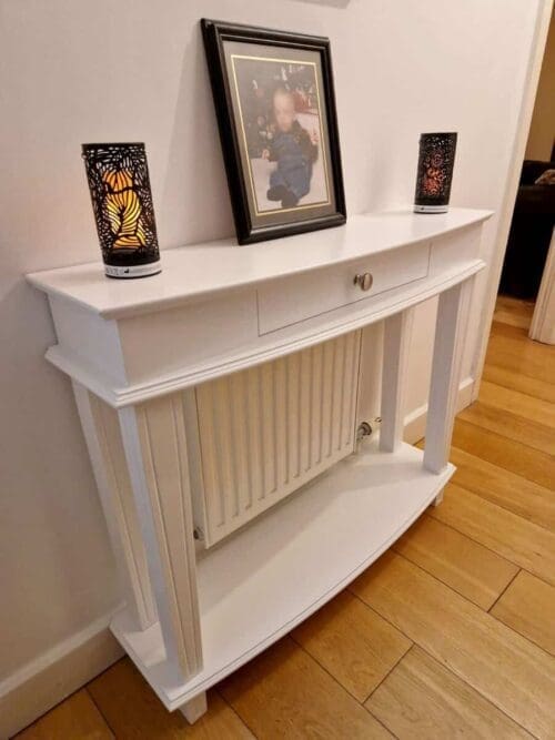 console table with curved top and lower shelf covering a radiator.