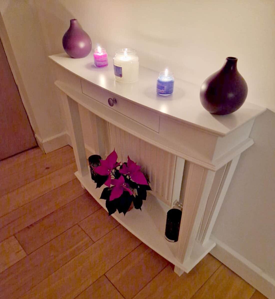console table with curved top and lower shelf covering a radiator.
