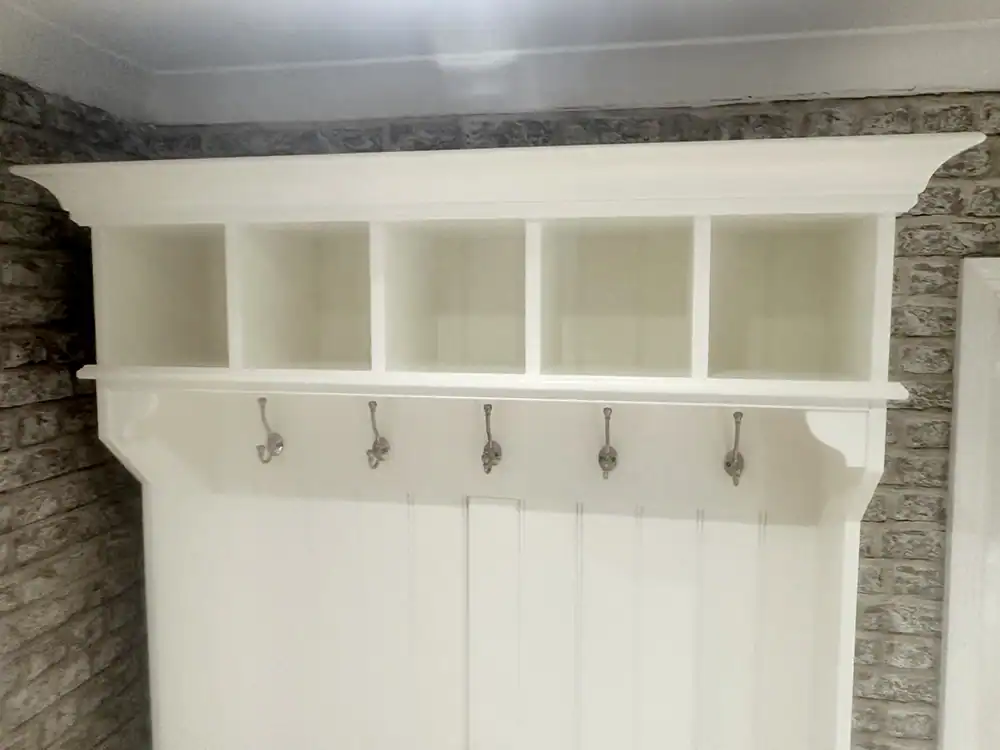 Upper storage cubbies and decorative cornice on storage unit